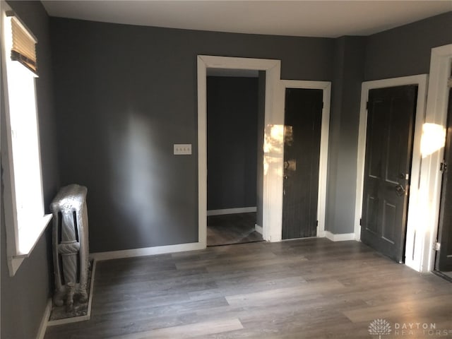 unfurnished room featuring dark hardwood / wood-style flooring and radiator heating unit