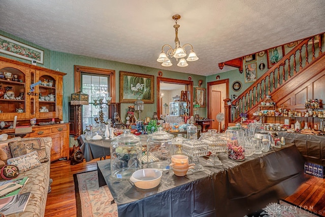 dining area featuring hardwood / wood-style floors, a chandelier, and a textured ceiling