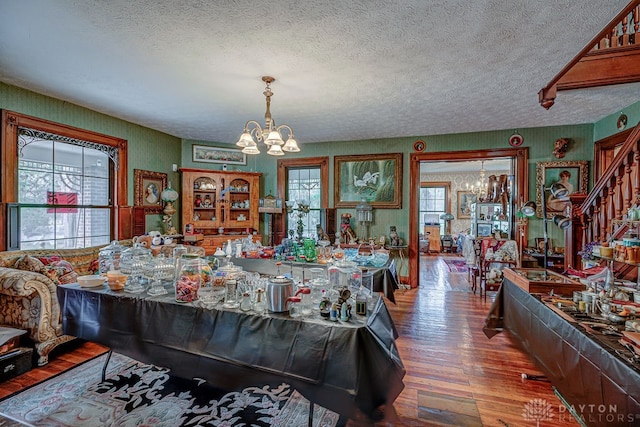 game room with a notable chandelier, a textured ceiling, and wood-type flooring