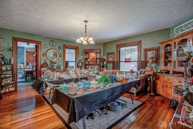 dining area featuring a notable chandelier, a textured ceiling, and hardwood / wood-style flooring