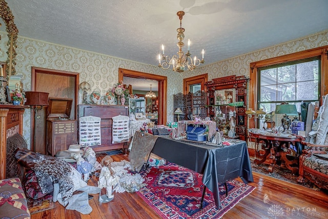 interior space featuring a notable chandelier, wood-type flooring, and a textured ceiling