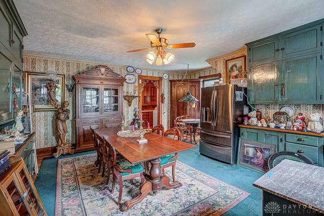 carpeted dining room featuring a textured ceiling and ceiling fan