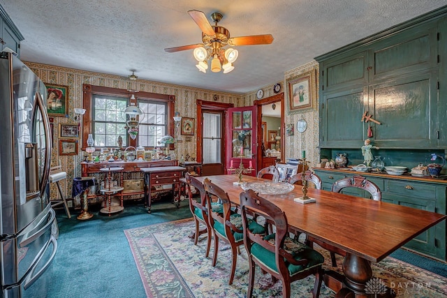 carpeted dining space with a textured ceiling and ceiling fan