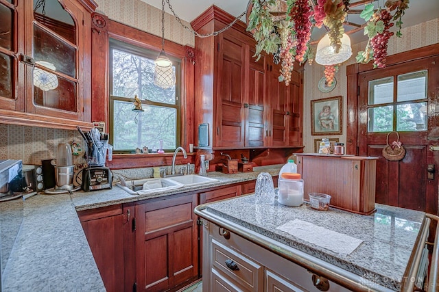 kitchen with sink, a kitchen island, and pendant lighting