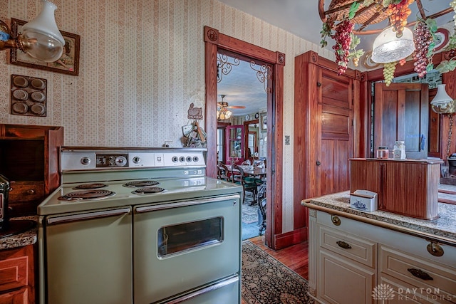 kitchen with white cabinetry, ceiling fan, white electric stove, and light hardwood / wood-style flooring