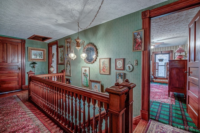 hallway with a chandelier and a textured ceiling