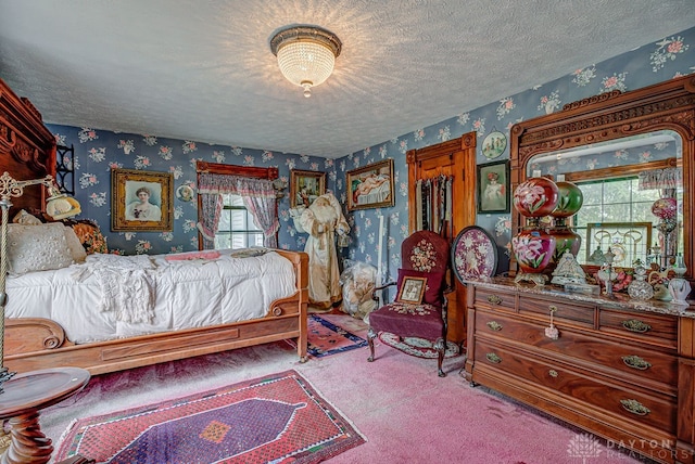 bedroom with a textured ceiling and light colored carpet