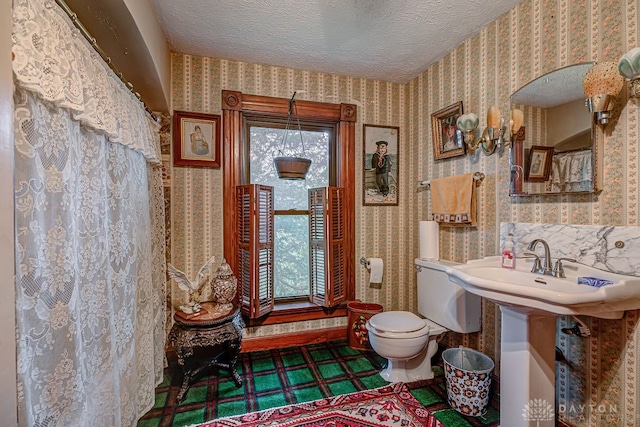 bathroom featuring a textured ceiling and toilet