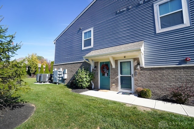 entrance to property featuring central AC and a lawn