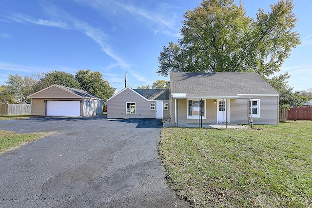 view of front of house with a front yard, an outbuilding, a garage, and covered porch