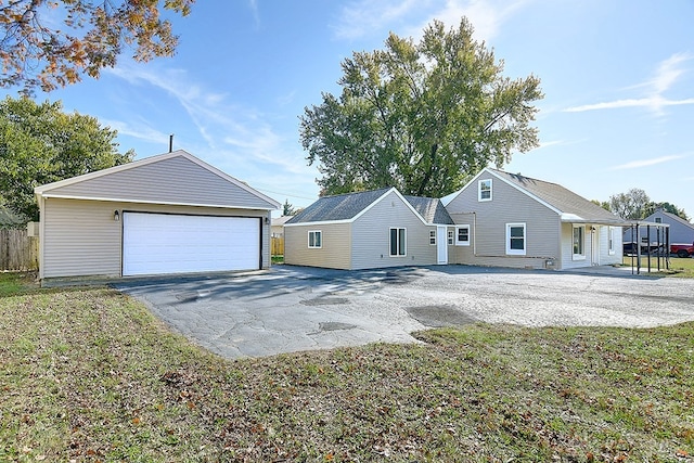 exterior space featuring an outdoor structure, a front yard, and a garage