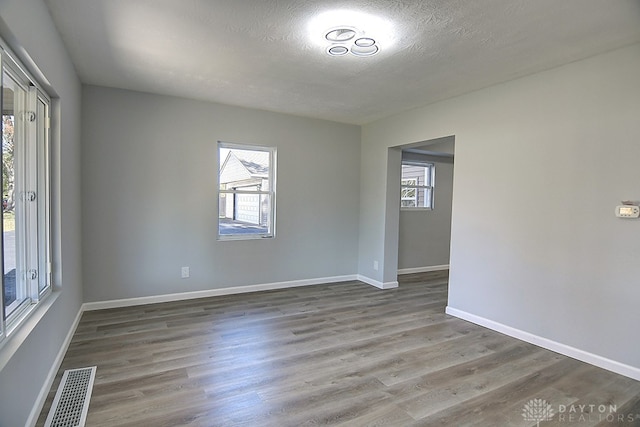 spare room with a textured ceiling and wood-type flooring