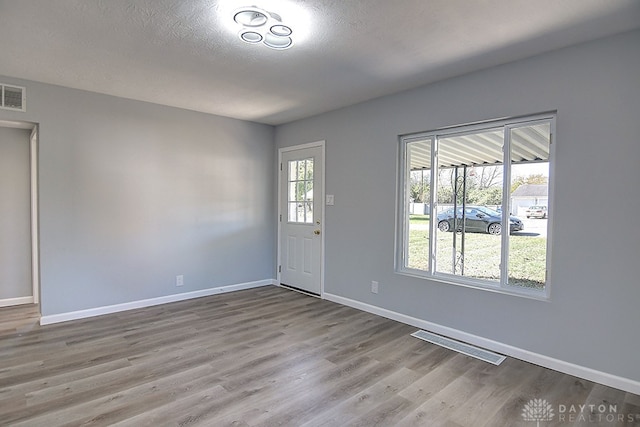 entrance foyer with light hardwood / wood-style flooring and a textured ceiling