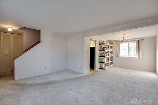 unfurnished room with a notable chandelier and light colored carpet