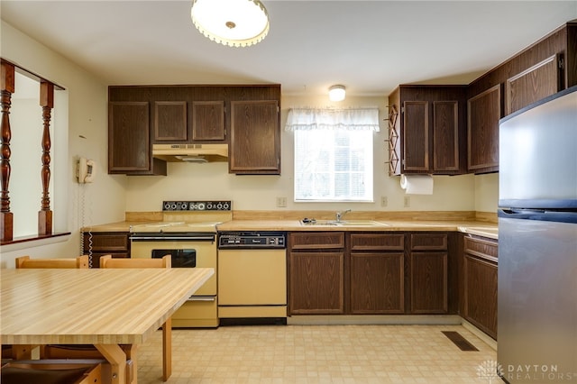 kitchen featuring sink, dishwasher, dark brown cabinets, stainless steel refrigerator, and range with electric stovetop