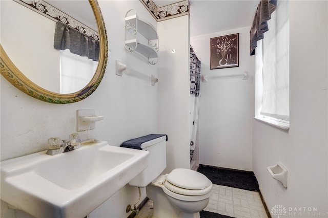 bathroom with toilet, a shower with curtain, and sink