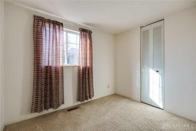 unfurnished bedroom with a closet and carpet floors