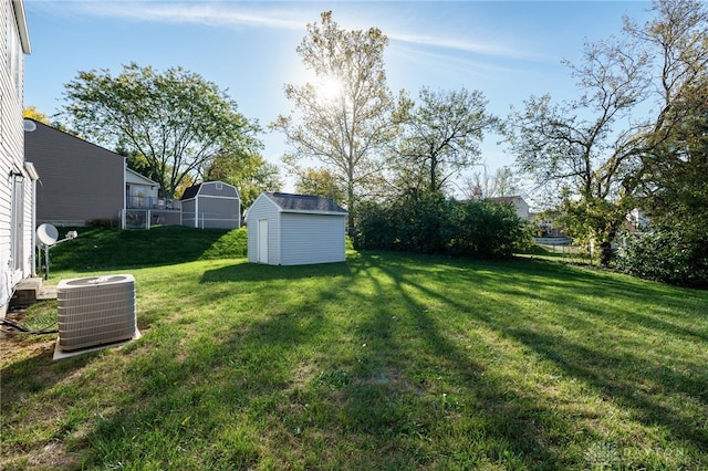 view of yard featuring a storage unit and central AC