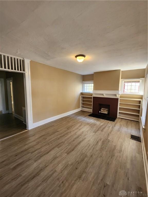 unfurnished living room with hardwood / wood-style floors and plenty of natural light