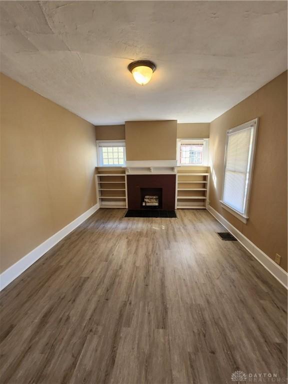 unfurnished living room with hardwood / wood-style flooring and a wealth of natural light