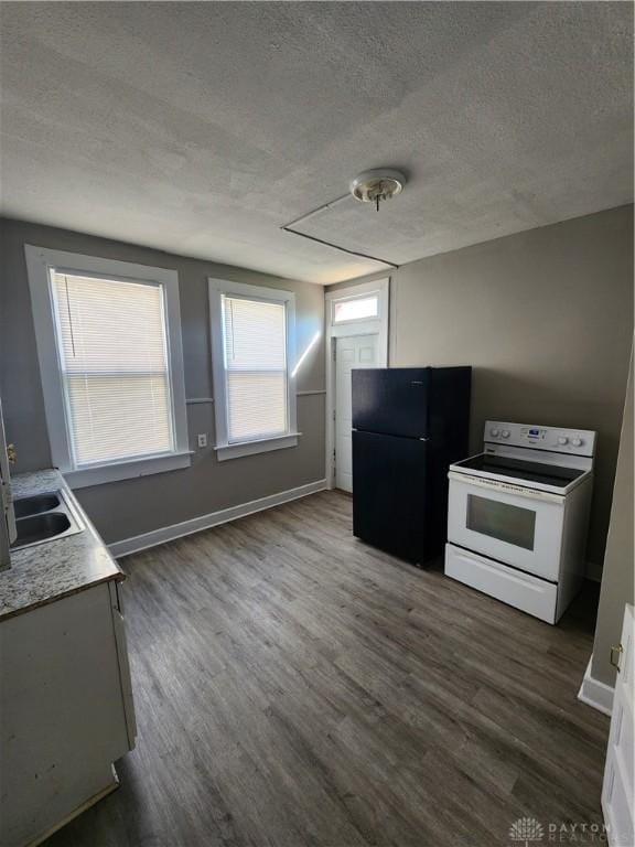 kitchen featuring white range with electric cooktop, black fridge, dark wood-type flooring, and a textured ceiling