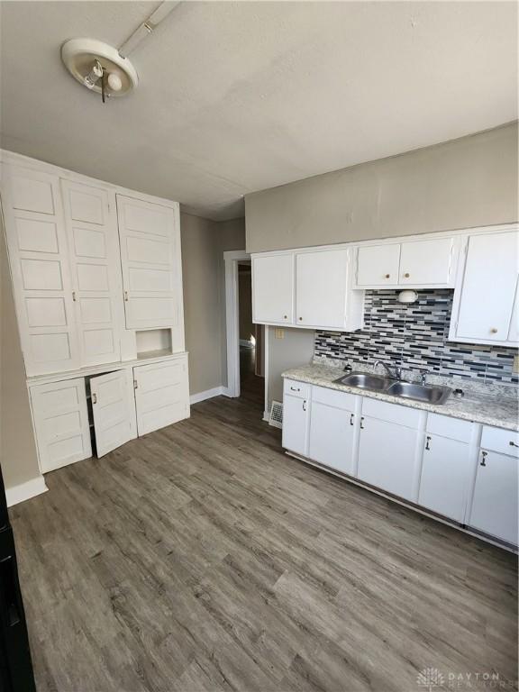 kitchen featuring decorative backsplash, dark hardwood / wood-style flooring, white cabinetry, and sink