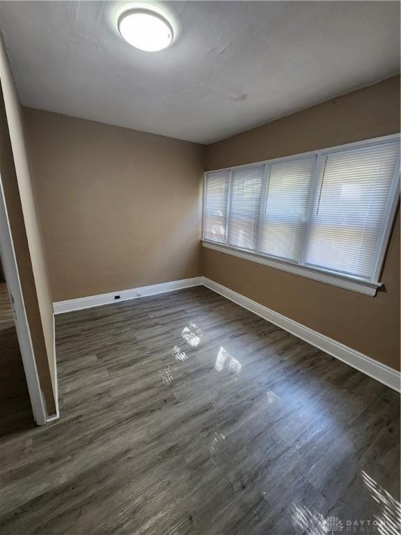 spare room featuring dark wood-type flooring