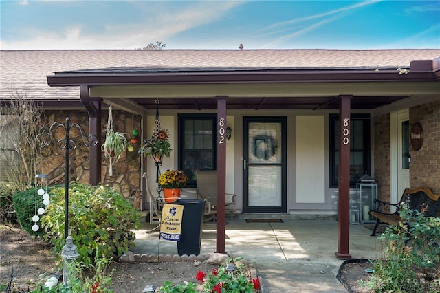 view of exterior entry featuring covered porch