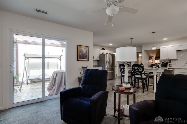 carpeted living room featuring ceiling fan