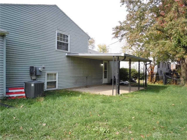 back of house with a patio area, a yard, and central AC