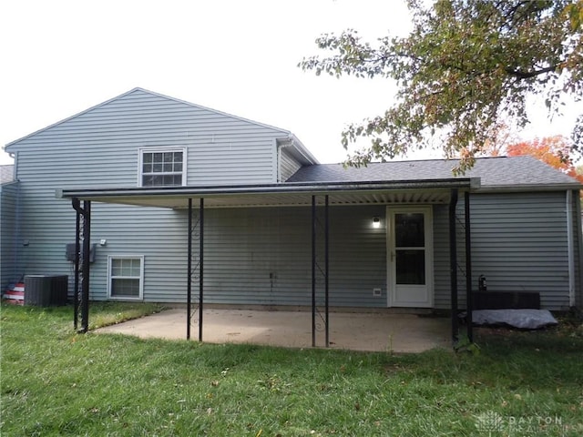 rear view of house featuring central AC unit, a yard, and a patio