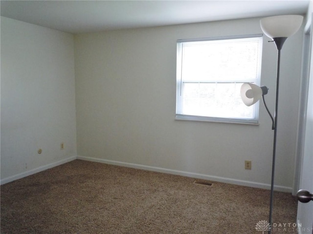 empty room featuring carpet flooring and a wealth of natural light