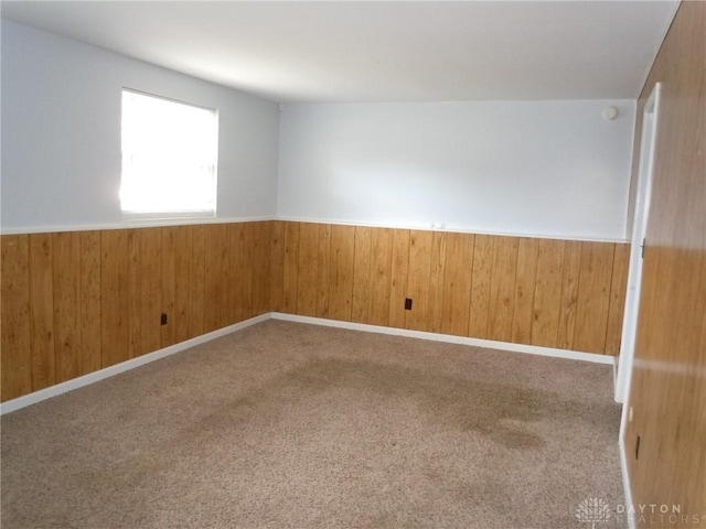 empty room with wood walls and carpet floors