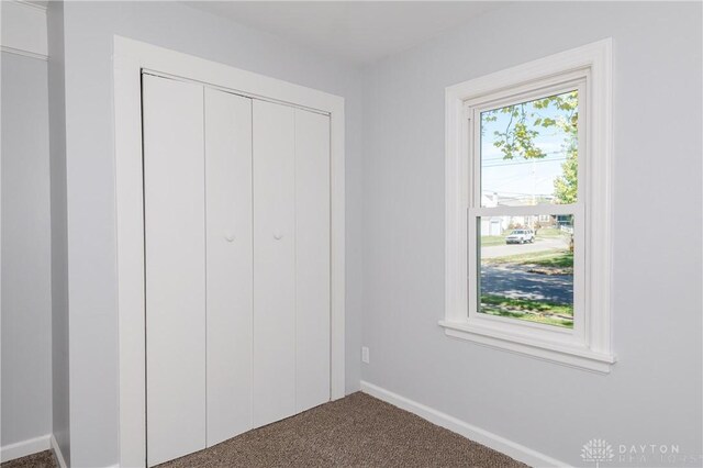 unfurnished bedroom with a closet and carpet floors