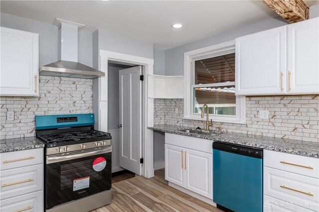 kitchen with appliances with stainless steel finishes, wall chimney exhaust hood, white cabinetry, and light stone counters