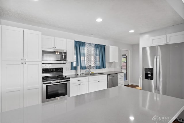 kitchen with white cabinetry, sink, a textured ceiling, and appliances with stainless steel finishes