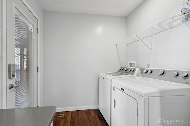 washroom with washing machine and dryer and dark wood-type flooring