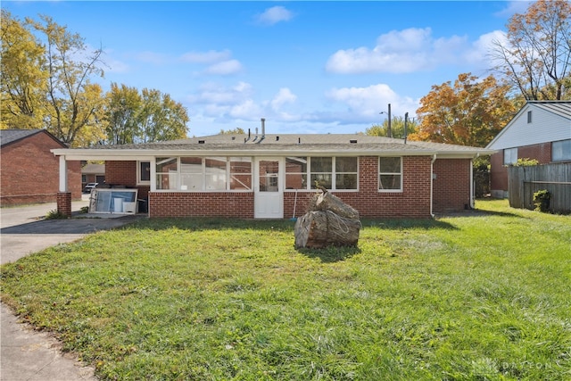 single story home featuring a sunroom and a front yard