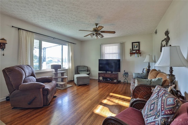 living room with ceiling fan, hardwood / wood-style flooring, and a textured ceiling