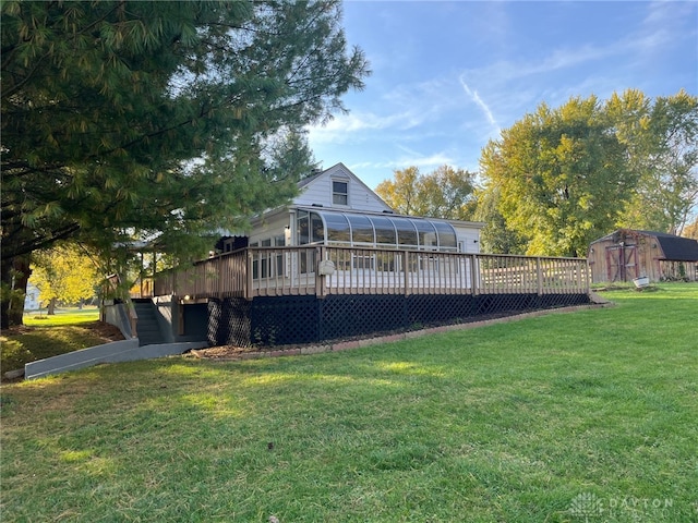 back of house featuring a sunroom, a yard, and a wooden deck