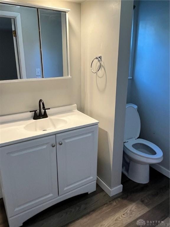 bathroom with vanity, toilet, and wood-type flooring