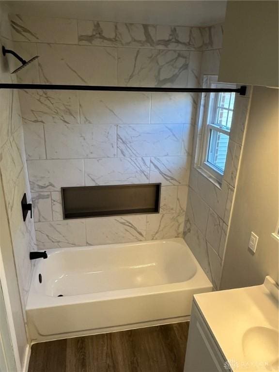 bathroom with vanity, hardwood / wood-style flooring, and tiled shower / bath