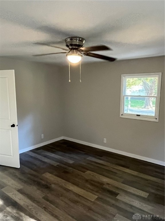 unfurnished room with ceiling fan, dark hardwood / wood-style flooring, and a textured ceiling