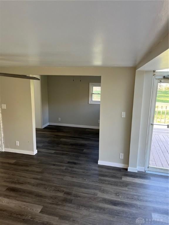 unfurnished room featuring dark hardwood / wood-style flooring and a wealth of natural light