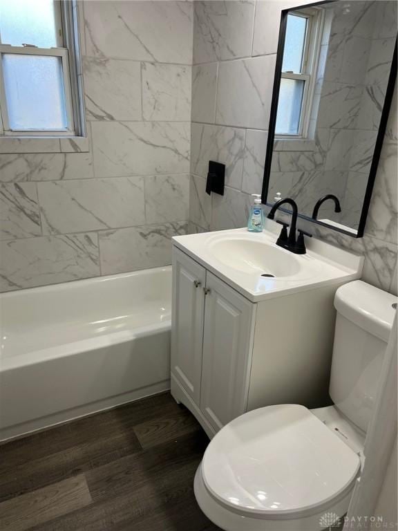 full bathroom featuring vanity, tiled shower / bath combo, tile walls, and plenty of natural light