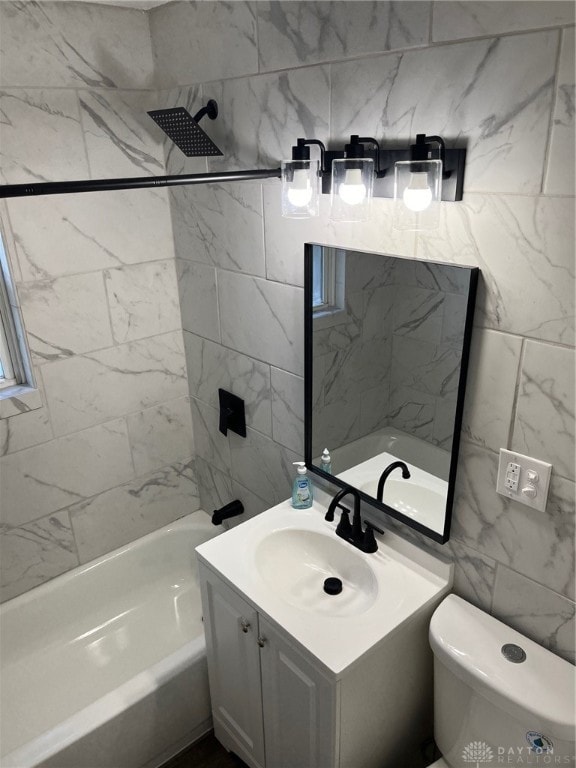 full bathroom featuring vanity, toilet, and tile walls