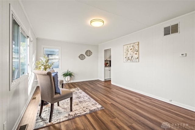 living area featuring ornamental molding and dark hardwood / wood-style floors