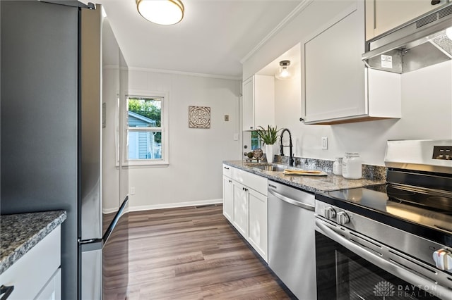 kitchen with sink, appliances with stainless steel finishes, white cabinets, and extractor fan