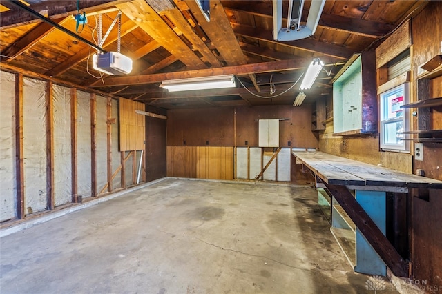 garage featuring wood walls and a garage door opener