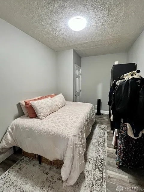 bedroom featuring a textured ceiling and wood-type flooring